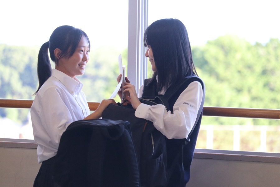 潮風の薫る校舎で話している生徒